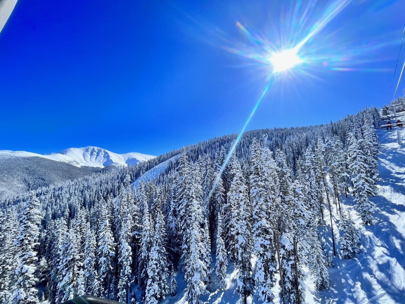 Bluebird day over snow-covered peaks and pines at Winter Park