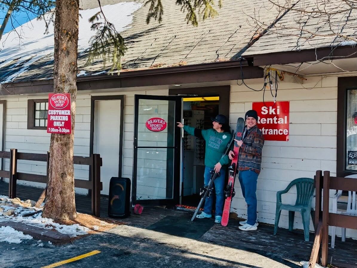 Customers with skis outside the Beavers Sports Shop rental entrance