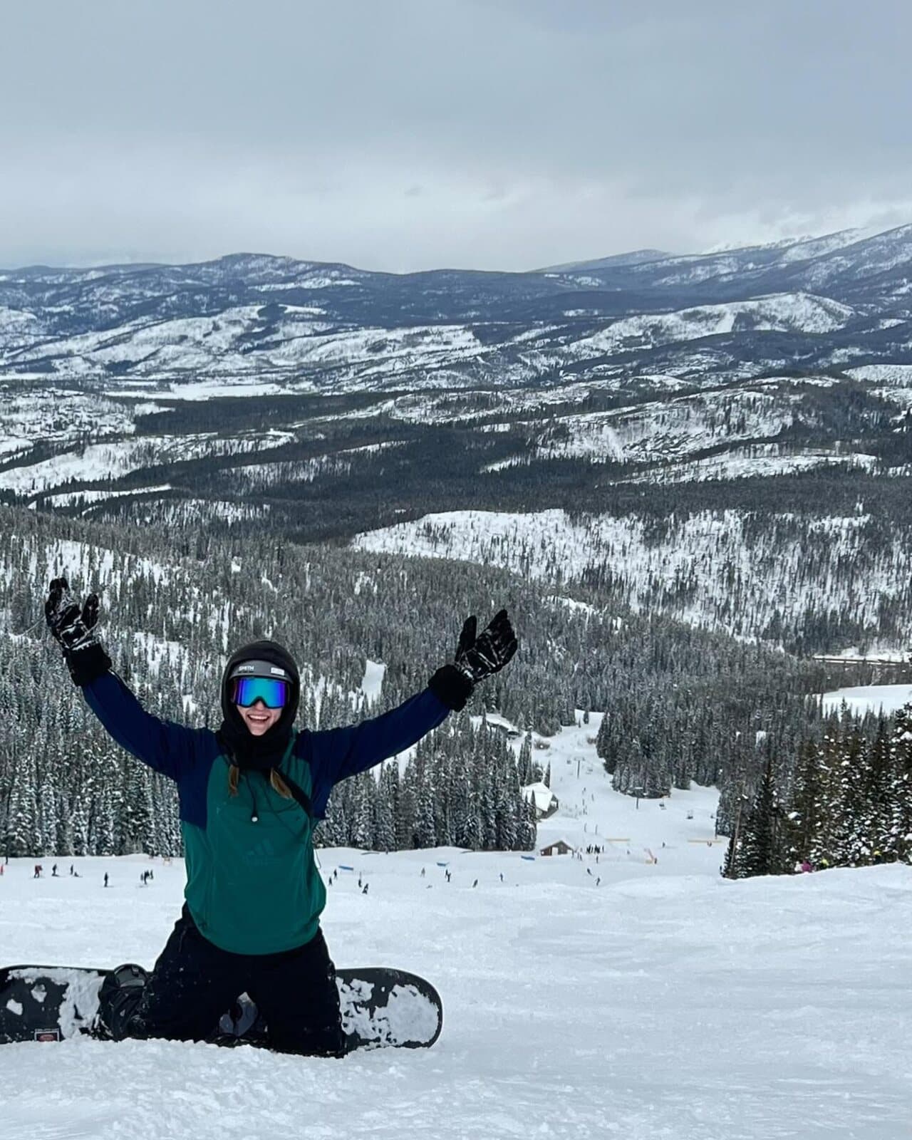 Snowboarder celebrating at the summit above Winter Park